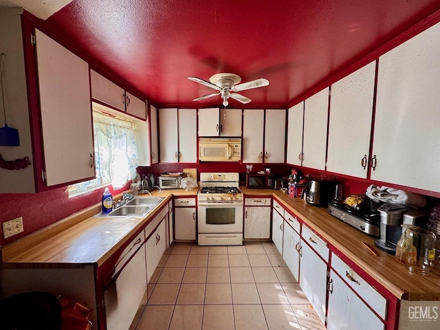 kitchen with sink, white cabinets, and white appliances