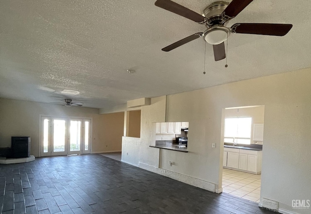 interior space featuring a textured ceiling, light hardwood / wood-style floors, ceiling fan, and sink