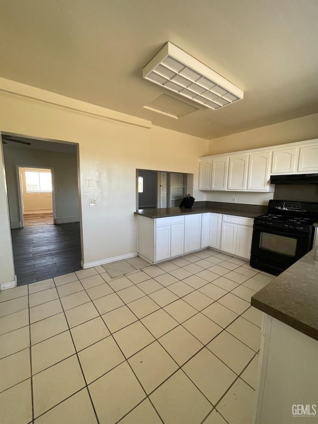 kitchen featuring gas stove, white cabinetry, and light tile patterned flooring