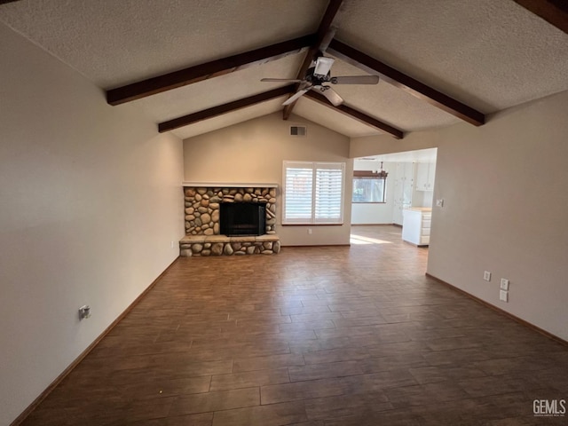 unfurnished living room featuring a textured ceiling, a ceiling fan, dark wood finished floors, a stone fireplace, and baseboards