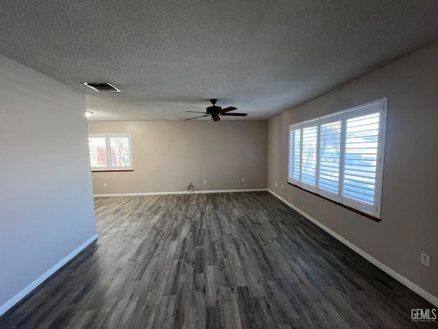 spare room with a ceiling fan, dark wood finished floors, baseboards, and a textured ceiling