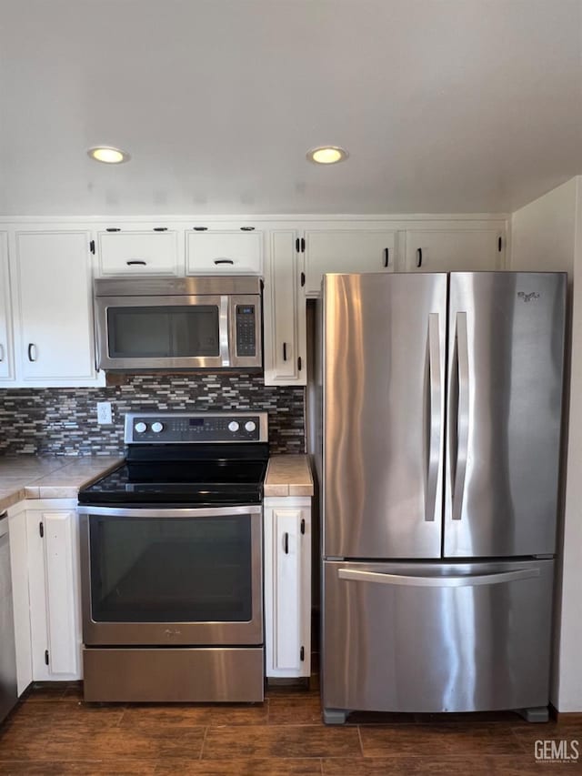 kitchen with appliances with stainless steel finishes, white cabinets, and recessed lighting