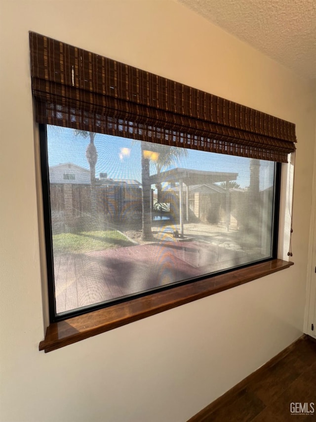 detailed view of wood finished floors and a textured ceiling