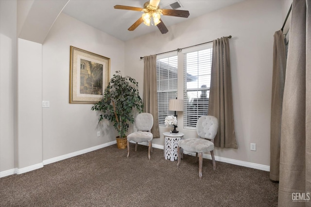 sitting room with ceiling fan and dark carpet