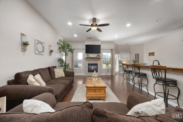 living room with ceiling fan, a fireplace, dark hardwood / wood-style flooring, and sink