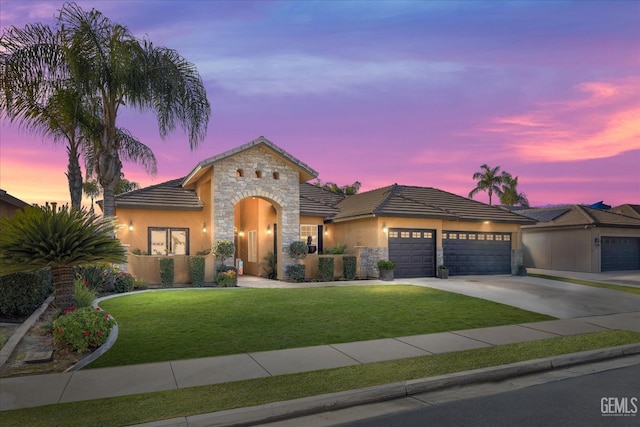 view of front of property with a yard and a garage