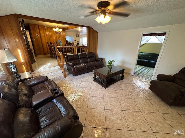 1022 9th Ave, Delano, CA 93215 - living room with a chandelier, a textured ceiling, a ceiling fan, light tile patterned floors, and wood walls