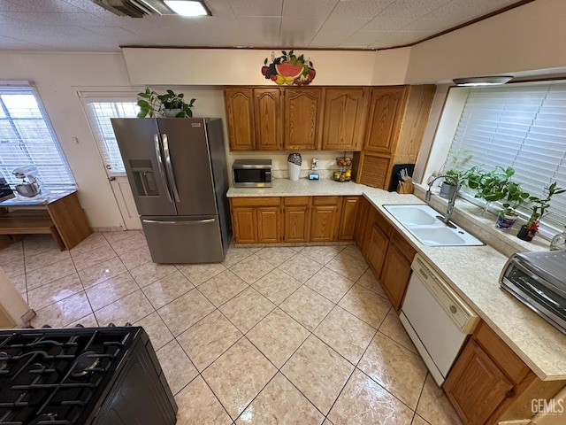 1022 9th Ave, Delano, CA 93215 - kitchen featuring appliances with stainless steel finishes, brown cabinetry, light countertops, light tile patterned floors, and ornamental molding