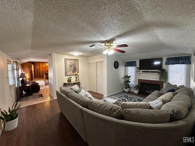 1022 9th Ave, Delano, CA 93215 - living room with a fireplace, dark wood-type flooring, healthy amount of natural light, a ceiling fan, and a textured ceiling