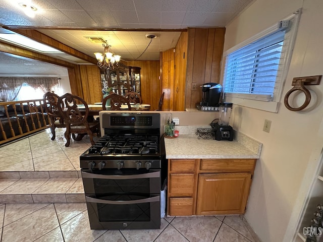 1022 9th Ave, Delano, CA 93215 - kitchen featuring double oven range, wood walls, a chandelier, light countertops, and brown cabinetry
