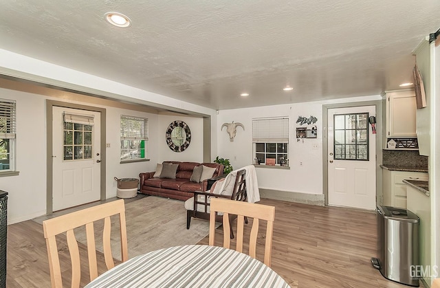 dining room featuring light wood finished floors, recessed lighting, and a textured ceiling