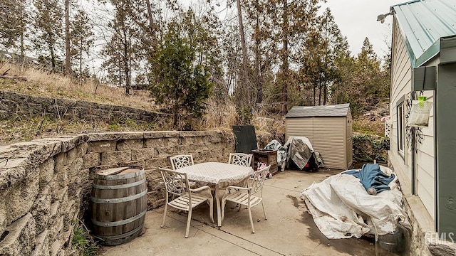 view of patio / terrace with a storage unit, outdoor dining area, and an outdoor structure