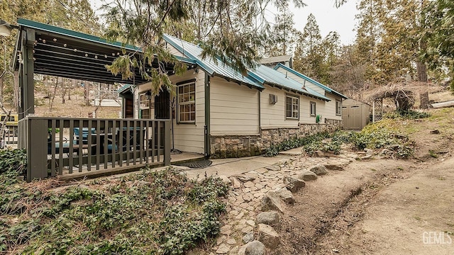 view of home's exterior featuring stone siding and metal roof