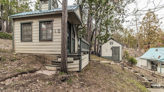 view of home's exterior featuring metal roof and an outdoor structure