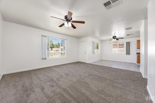 132 E Center St, Taft, CA 93268 - unfurnished living room featuring ceiling fan, light colored carpet, plenty of natural light, and light tile patterned floors