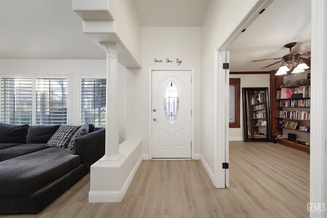 entrance foyer with ornate columns, ceiling fan, and light wood-type flooring