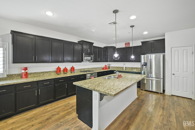 18019 Lapis Ln, San Bernardino, CA 92407 - kitchen featuring appliances with stainless steel finishes, light stone countertops, decorative light fixtures, dark cabinetry, and recessed lighting