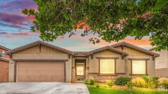 18019 Lapis Ln, San Bernardino, CA 92407 - view of front of home with concrete driveway, stone siding, a garage, board and batten siding, and stucco siding
