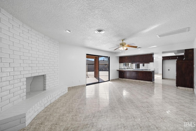 unfurnished living room with ceiling fan, a fireplace, and a textured ceiling