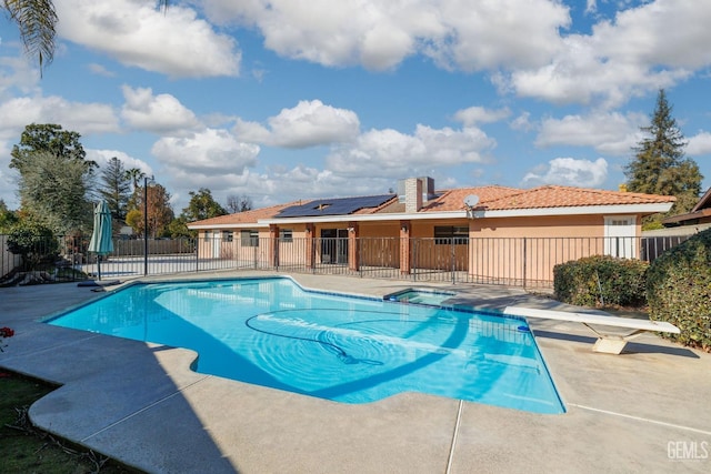 view of swimming pool featuring a patio and a diving board