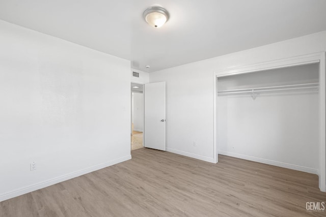 unfurnished bedroom featuring a closet and light wood-type flooring