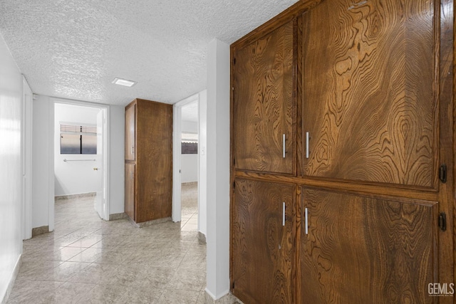 hall featuring a textured ceiling