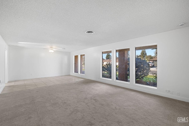 empty room with a textured ceiling, ceiling fan, and light carpet