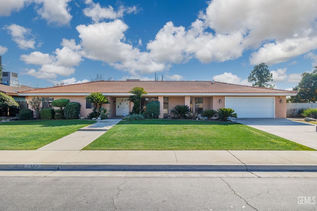 ranch-style house with a garage and a front lawn