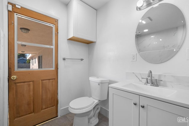 bathroom featuring tile patterned flooring, vanity, and toilet