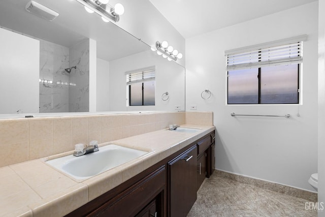 bathroom with vanity, toilet, decorative backsplash, and walk in shower