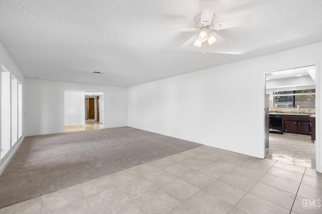 carpeted spare room with ceiling fan, sink, and a textured ceiling