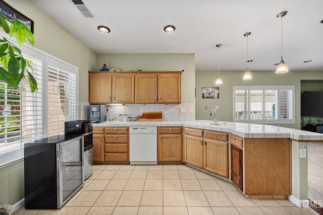 2109 Via Tuscania Ave, Delano, CA 93215 - kitchen with white dishwasher, a sink, plenty of natural light, and tasteful backsplash