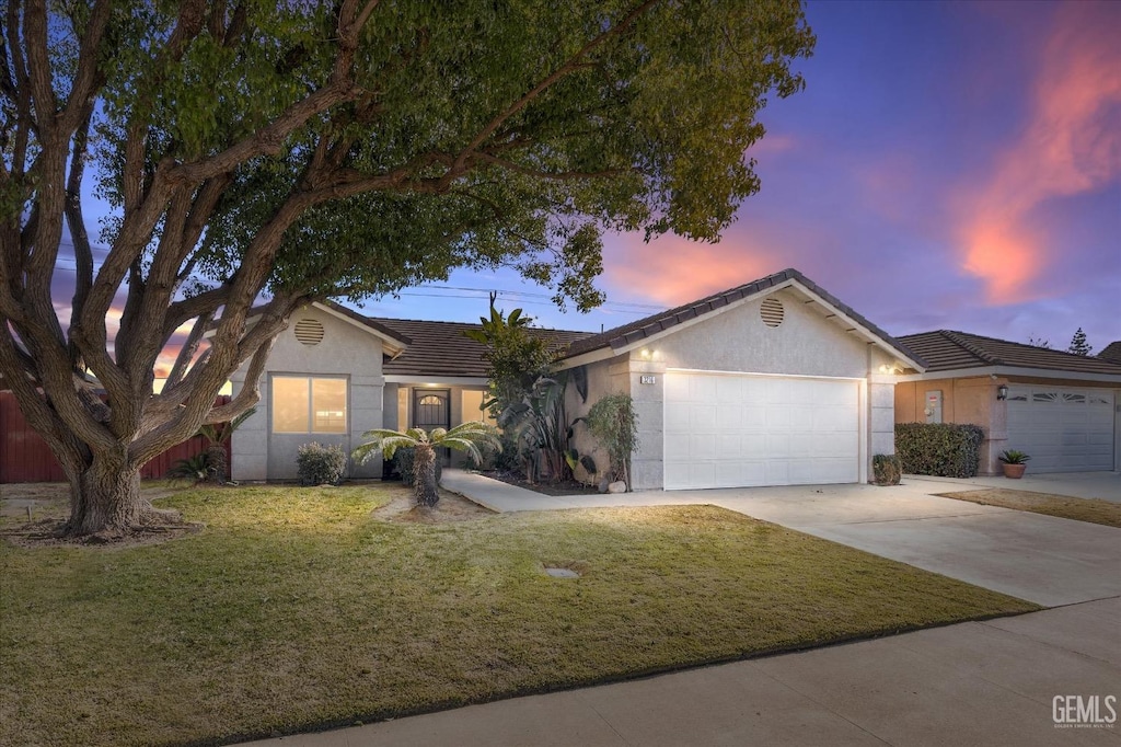 single story home with a lawn and a garage