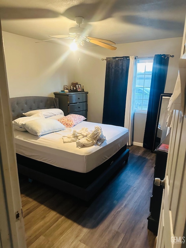 bedroom featuring ceiling fan and dark wood-type flooring