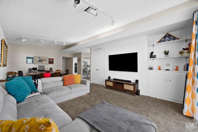 carpeted living room featuring track lighting and a textured ceiling