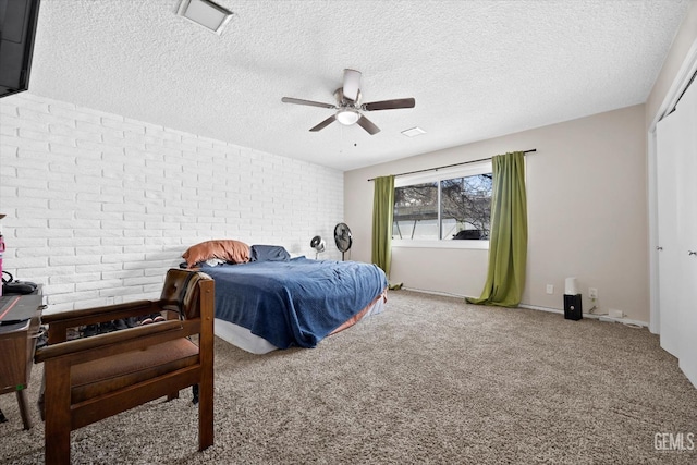 bedroom with ceiling fan, brick wall, carpet floors, and a textured ceiling