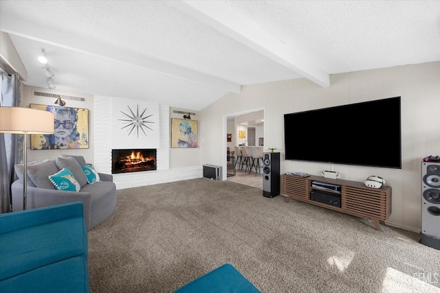 carpeted living room featuring vaulted ceiling with beams, a textured ceiling, and a brick fireplace