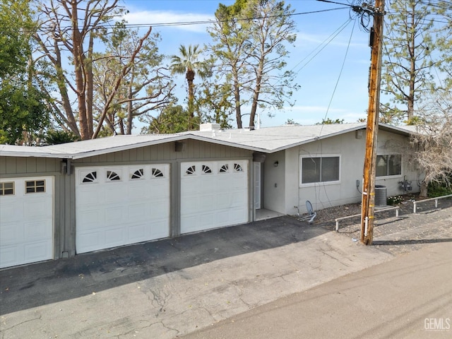 single story home featuring central AC and a garage