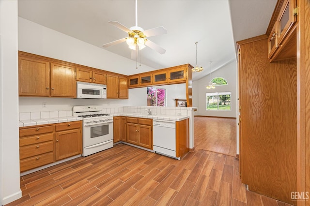 3625 Bernard St Unit 5, Bakersfield, CA 93306 - kitchen with white appliances, a peninsula, brown cabinetry, tile counters, and wood finished floors
