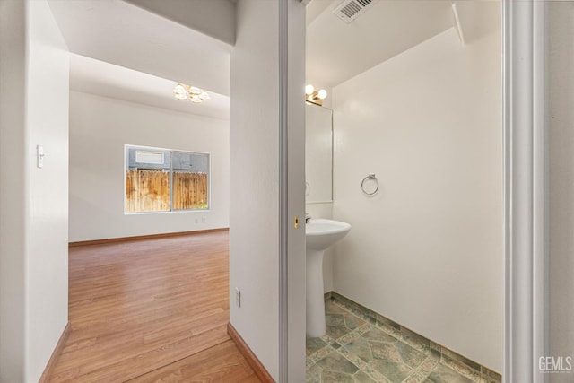 3625 Bernard St Unit 5, Bakersfield, CA 93306 - bathroom featuring a chandelier, wood finished floors, and baseboards