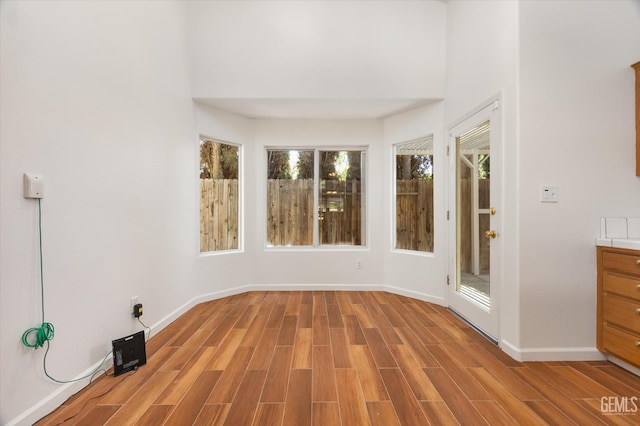 3625 Bernard St Unit 5, Bakersfield, CA 93306 - empty room featuring light wood finished floors, baseboards, and a towering ceiling