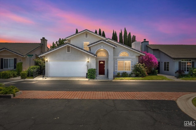 3625 Bernard St Unit 5, Bakersfield, CA 93306 - view of front facade featuring an attached garage, stucco siding, decorative driveway, and a chimney