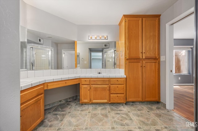 3625 Bernard St Unit 5, Bakersfield, CA 93306 - bathroom featuring a shower stall, vanity, and stone finish flooring