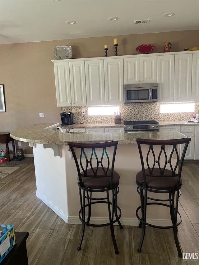 10011 Rosebud Ave, Bakersfield, CA 93311 - kitchen featuring stainless steel appliances, white cabinetry, dark wood-style floors, and recessed lighting