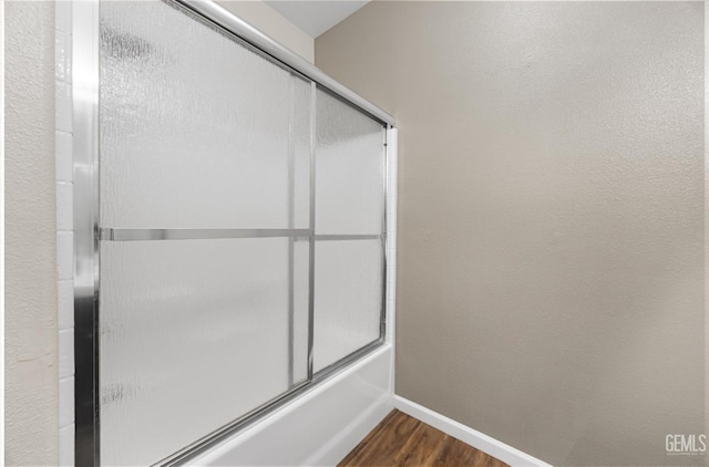 11313 Valletta Ave, Bakersfield, CA 93312 - bathroom featuring wood finished floors and bath / shower combo with glass door