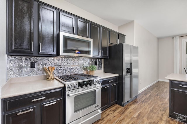 11313 Valletta Ave, Bakersfield, CA 93312 - kitchen with appliances with stainless steel finishes, wood finished floors, decorative backsplash, light countertops, and dark cabinets