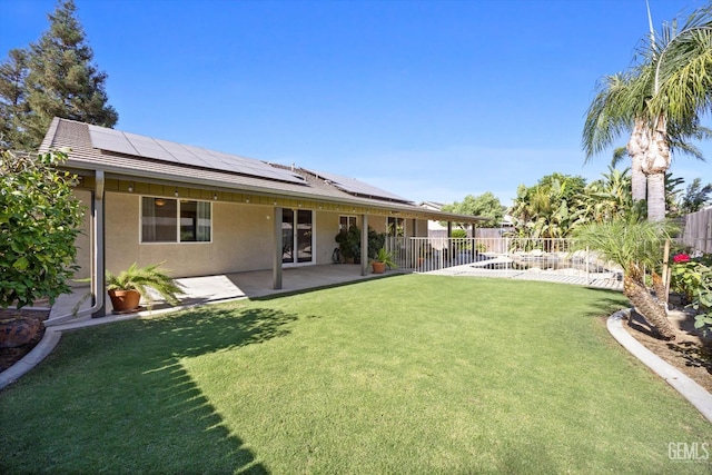11313 Valletta Ave, Bakersfield, CA 93312 - back of house with a fenced backyard, stucco siding, roof mounted solar panels, and a patio area