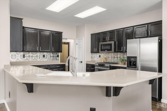 11313 Valletta Ave, Bakersfield, CA 93312 - kitchen featuring stainless steel appliances, dark cabinetry, and backsplash