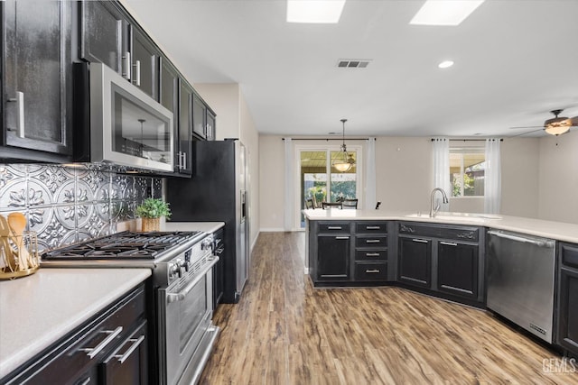 11313 Valletta Ave, Bakersfield, CA 93312 - kitchen with stainless steel appliances, dark cabinets, light wood finished floors, light countertops, and recessed lighting