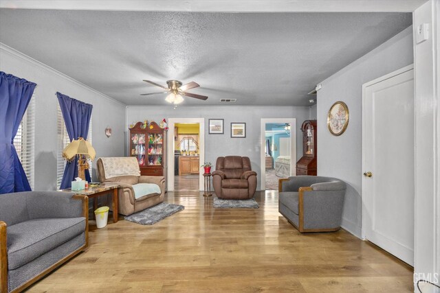 220 Tyler St, Taft, CA 93268 - living room featuring ceiling fan, ornamental molding, wood finished floors, and a textured ceiling